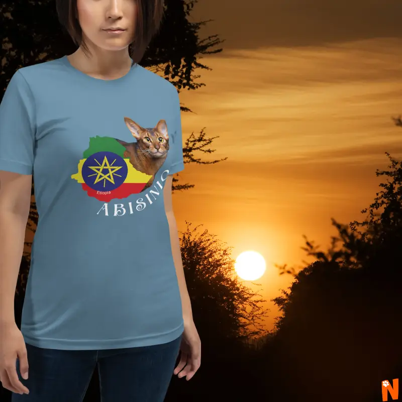 Mujer con camiseta azul de gato Abisinio con el mapa de Etiopía, sobre un atardecer en las tierras de Etiopía.