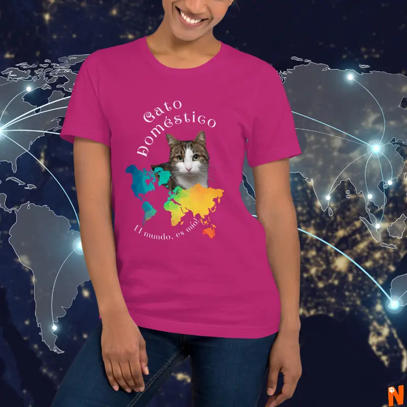 Mujer con camiseta (t-shirt) color fucsia o rosado intenso, que al frente tiene la foto de un gato de color blanco y atigrado de ojos verdes, que representa a todos los gatos domésticos del mundo, con un mapa del mundo en colores y el nombre de "gato doméstico" "el mundo es mío"