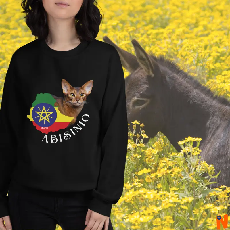 Sudadera color negro con la foto de un hermoso gato Abisinio, con el mapa de su país de origen Etiopía, sobre el fondo de un campo de flores amarillas (manzanilla tal vez), y un burro en medio de las flores.